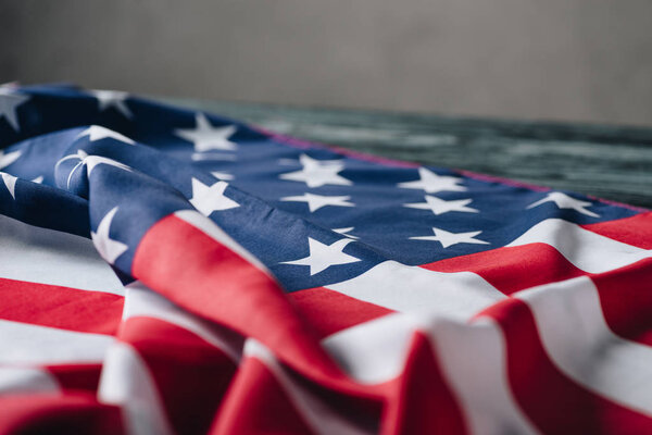 folded american flag on grey background, memorial day concept  