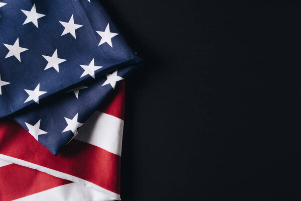 folded national flag of usa isolated on black, memorial day concept