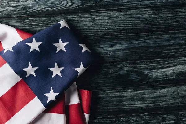 folded national flag of united states of america on wooden surface, memorial day concept
