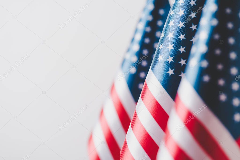 selective focus of united states of america national flags isolated on grey, memorial day concept