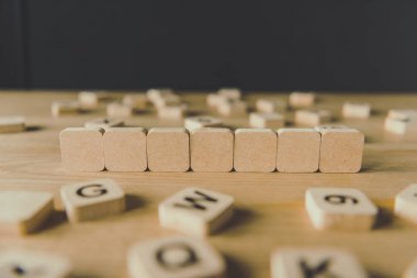 siyah izole ahşap yüzey üzerinde harflerile bloklar ile çevrili yedi boş küpler seçici odak