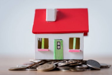 gri izole metal sikkeler üzerinde kırmızı çatı ve beyaz duvarlar ile ev modeli