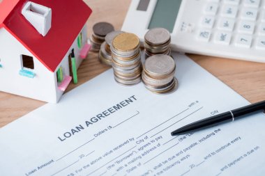 kredi anlaşması, ev modeli, hesap makinesi, ahşap yüzeyüzerinde gümüş ve altın sikke