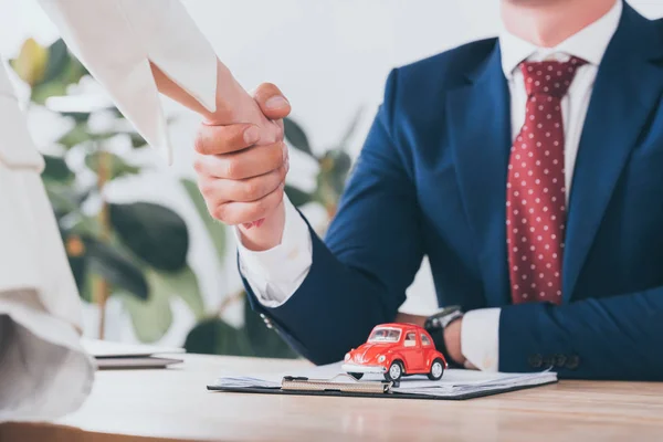 Visão Parcial Mulher Apertando Mãos Com Empresário Perto Brinquedo Carro — Fotografia de Stock