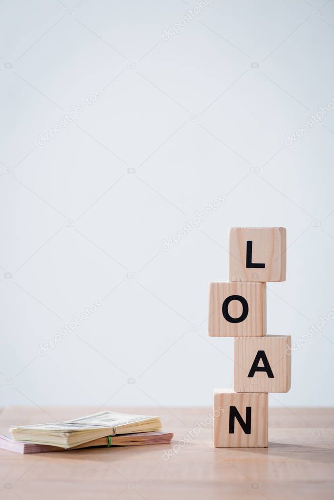 word loan made of wooden cubes and cars keys on wooden surface isolated on grey