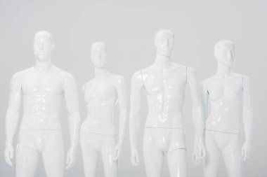 white plastic dummies in row isolated on grey  clipart