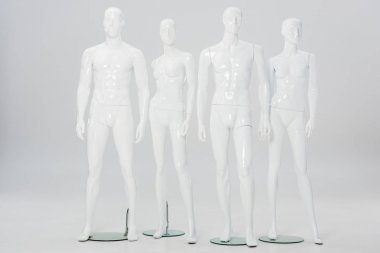 white plastic mannequins in row on grey  clipart