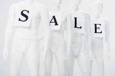 gri beyaz plastik mankenler üzerinde satış yazı ile kağıtları