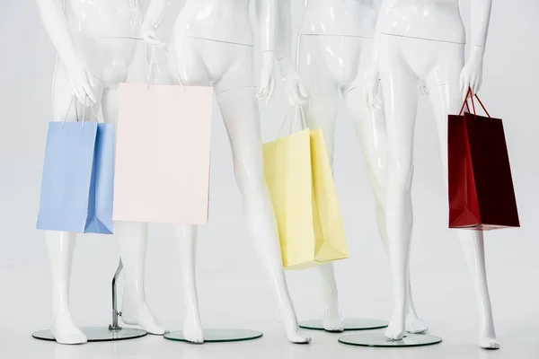 Weiße Schaufensterpuppen Mit Einkaufstaschen Isoliert Auf Grau — Stockfoto