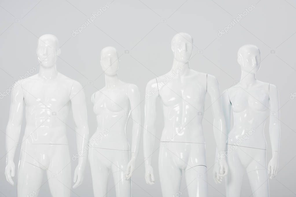 white plastic dummies in row isolated on grey 