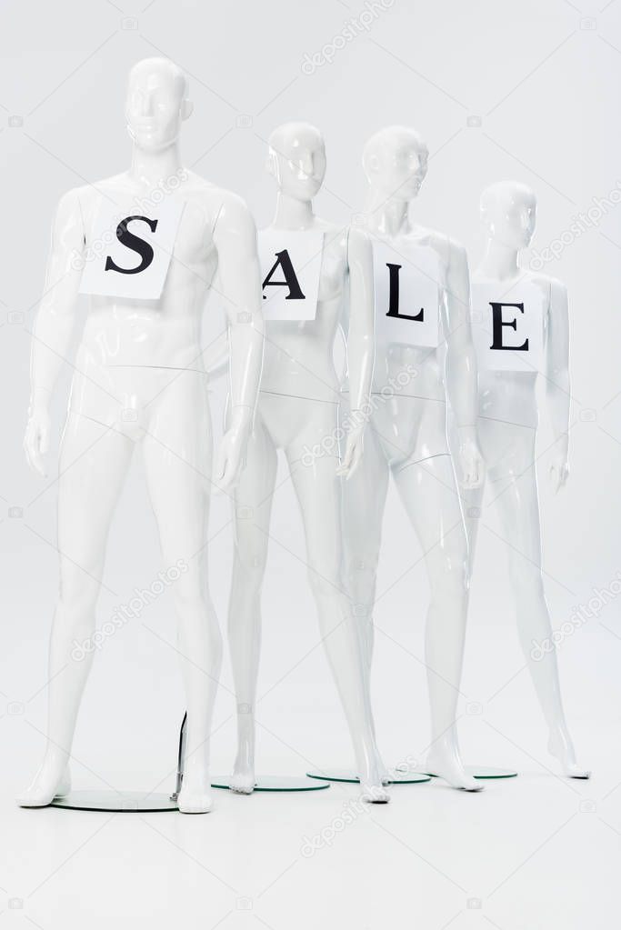 papers with sale lettering on white plastic dummies on grey