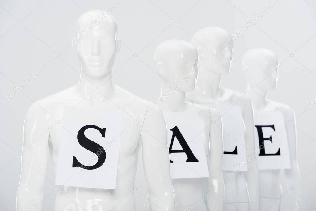 papers with sale lettering on white plastic dummies isolated on grey