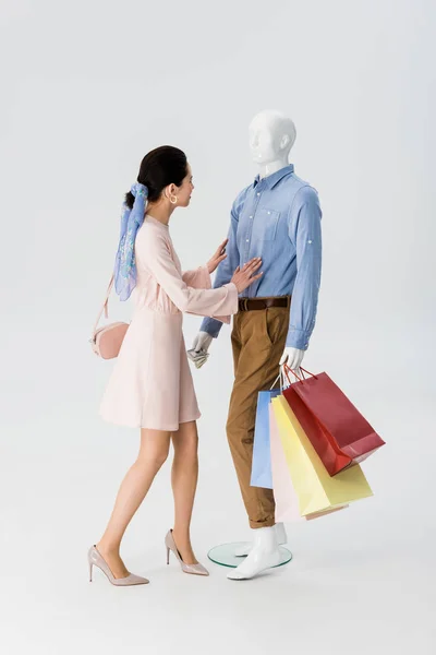 Hermosa Chica Empujando Maniquí Con Bolsas Compras Aisladas Gris —  Fotos de Stock