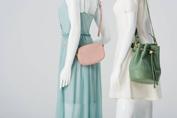 mannequins with bags and dresses isolated on grey