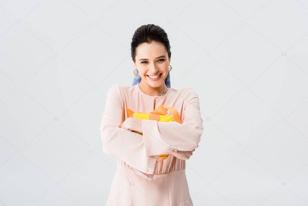 beautiful stylish young woman holding present and smiling isolated on grey