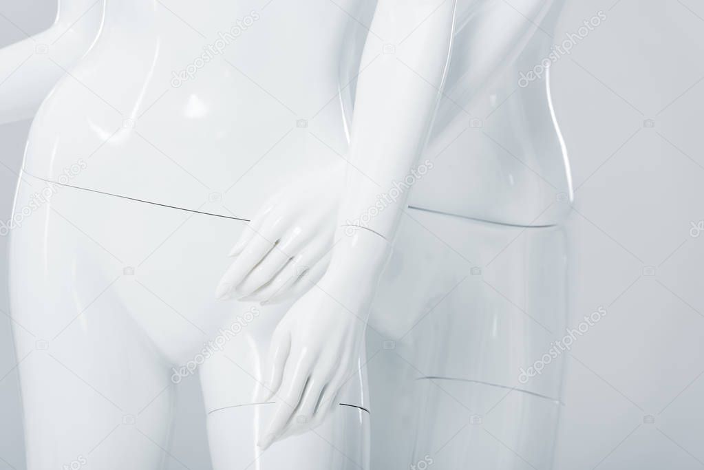 close up view of white plastic mannequins isolated on grey 