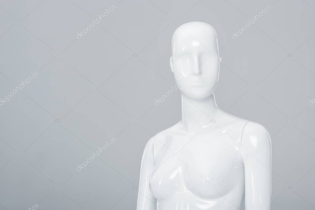 white plastic mannequin figure isolated on grey with copy space