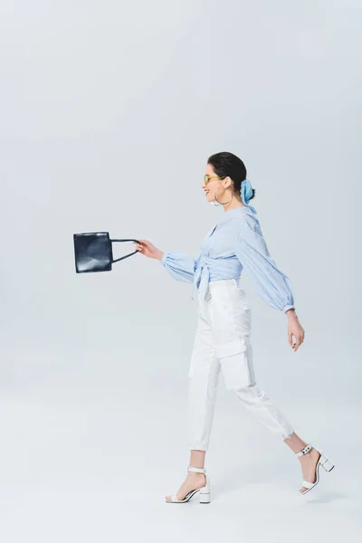 Hermosa Mujer Joven Con Estilo Gafas Sol Sosteniendo Bolsa Caminando — Foto de Stock