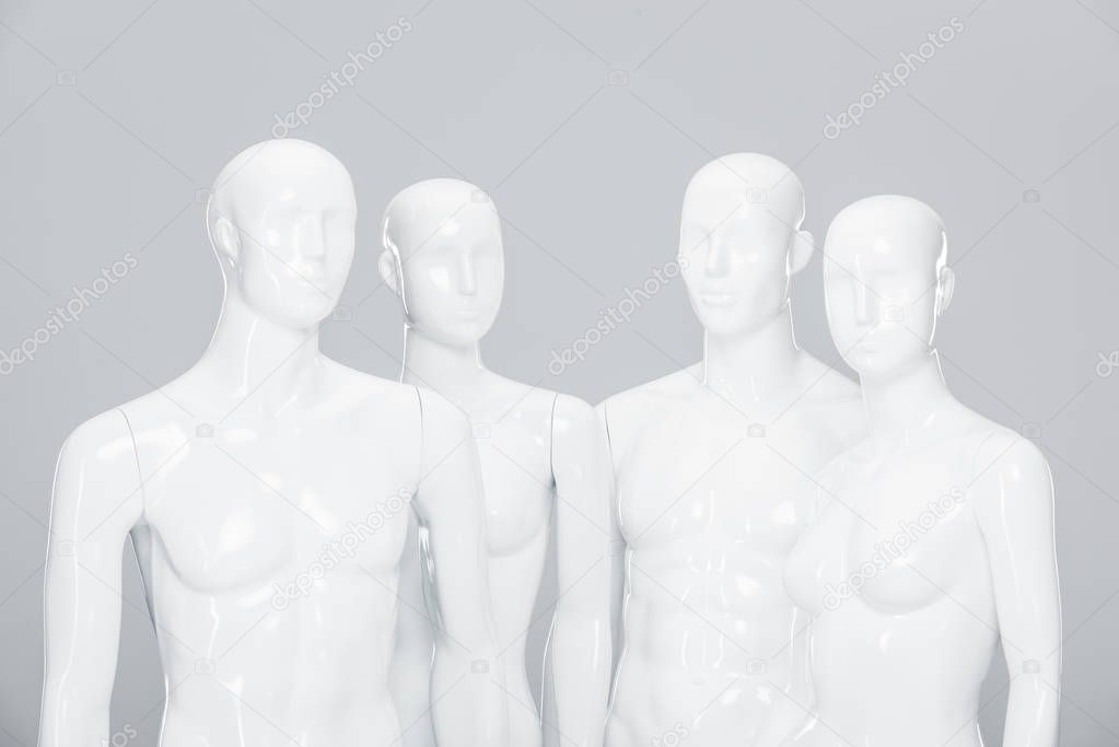 white plastic mannequin dolls isolated on grey 