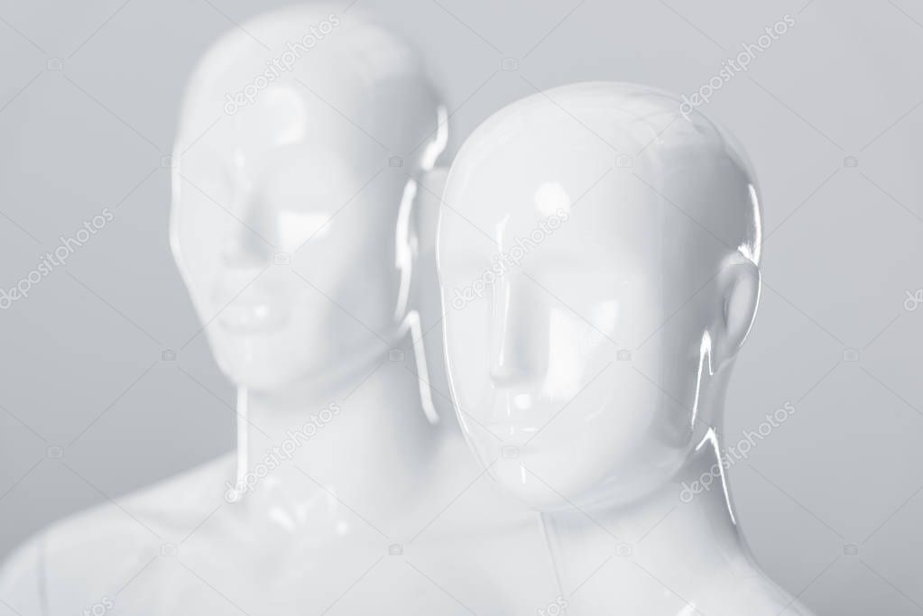 minimalistic white plastic mannequin dummies on grey 