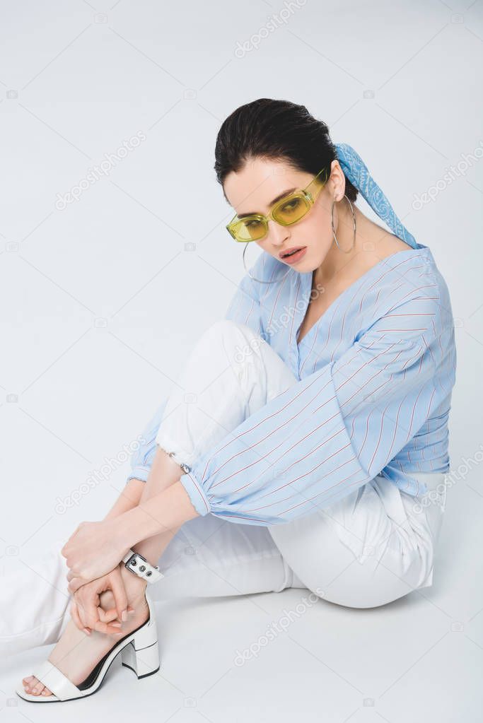 beautiful stylish girl sitting and posing on grey