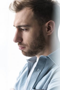 mavi gömlekli üzgün adam uzakta eve bakıyor
