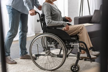 tekerlekli sandalyede engelli anne taşıyan adam kırpılmış görünümü