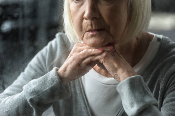 partial view of sad senior woman with grey hair