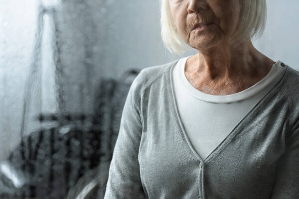 partial view of sad senior woman with grey hair