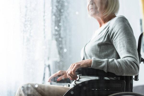 cropped view of disabled senior woman on wheelchair