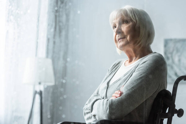 selective focus of pensive disabled senior woman with grey hair