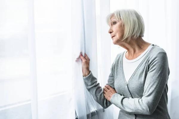 Smutna Starsza Kobieta Szarymi Włosami Patrząc Okno — Zdjęcie stockowe