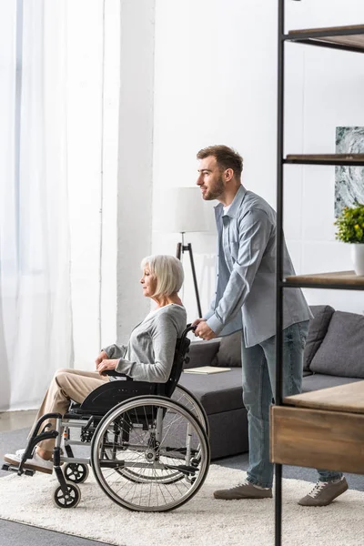 Vue Pleine Longueur Homme Portant Mère Handicapée Fauteuil Roulant — Photo