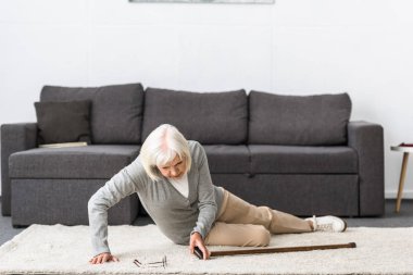 suffering senior woman with heart attack on carpet clipart