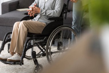 tekerlekli sandalyede kıdemli anne taşıyan adam kırpılmış görünümü