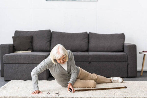 suffering senior woman with heart attack on carpet