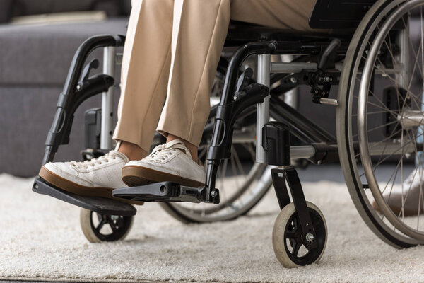 частичный вид пожилой женщины-инвалида в инвалидной коляске на дому
