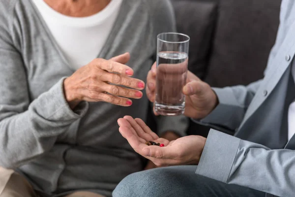 Vista Recortada Del Hombre Dando Madre Mayor Vaso Agua Medicina —  Fotos de Stock