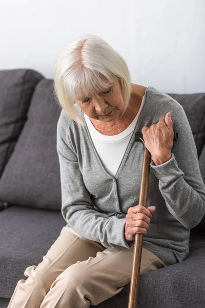 Fundersam Senior Kvinna Med Trä Käpp Sitter Soffan Vardagsrummet — Stockfoto