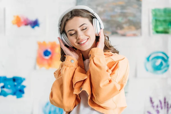 Happy Young Woman Orange Jacket Listening Music Headphones Closed Eyes — Stok fotoğraf