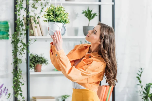 Pretty Young Woman Touching Flowerpot While Standing Rack Spacious Room — Stock Photo, Image