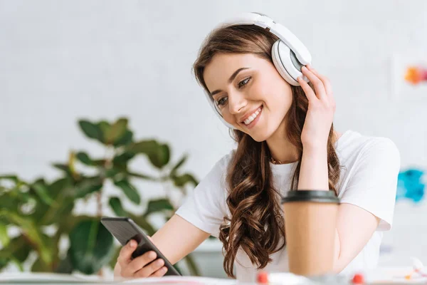 Jeune Femme Souriante Écoutant Musique Dans Les Écouteurs Utilisant Smartphone — Photo