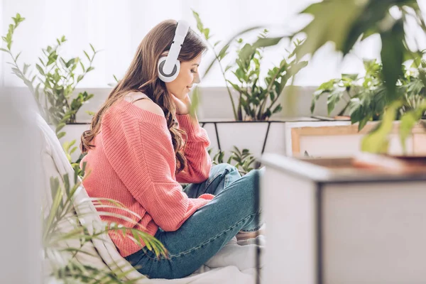 Pensive Young Woman Listening Music Headphones While Sitting Surrounded Green — Stock Photo, Image