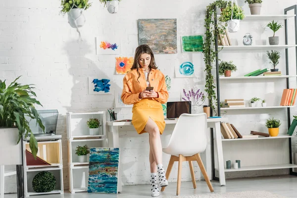 Jovem Atraente Usando Smartphone Quarto Decorado Com Plantas Verdes Pinturas — Fotografia de Stock