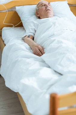 senior man in coma on bed in hospital clipart