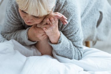 klinikte bilinçsiz yaşlı adam ve üzgün karısı kırpılmış görünümü