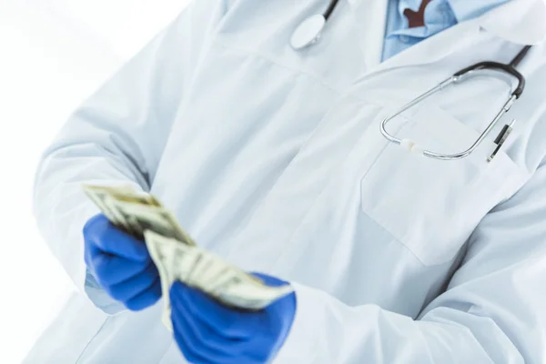 白にドル紙幣を数えるラテックス手袋の医師の部分的な見解 — ストック写真