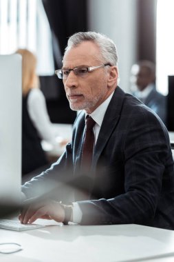 bilgisayar monitörü bakarak gözlük işadamı seçici odak 