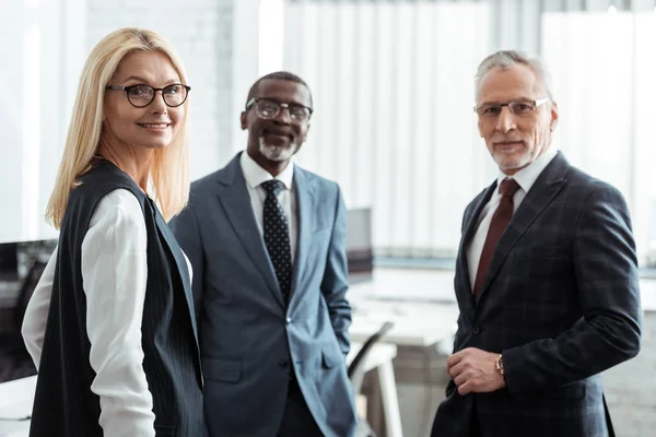 Selective Focus Cheerful Businesswoman Glasses Looking Camera Multicultural Partners — Stock Photo, Image