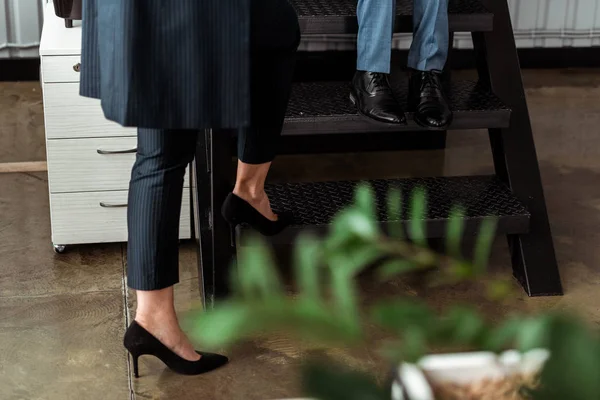 裁剪视图的妇女高跟鞋走在楼梯附近的合作伙伴 — 图库照片